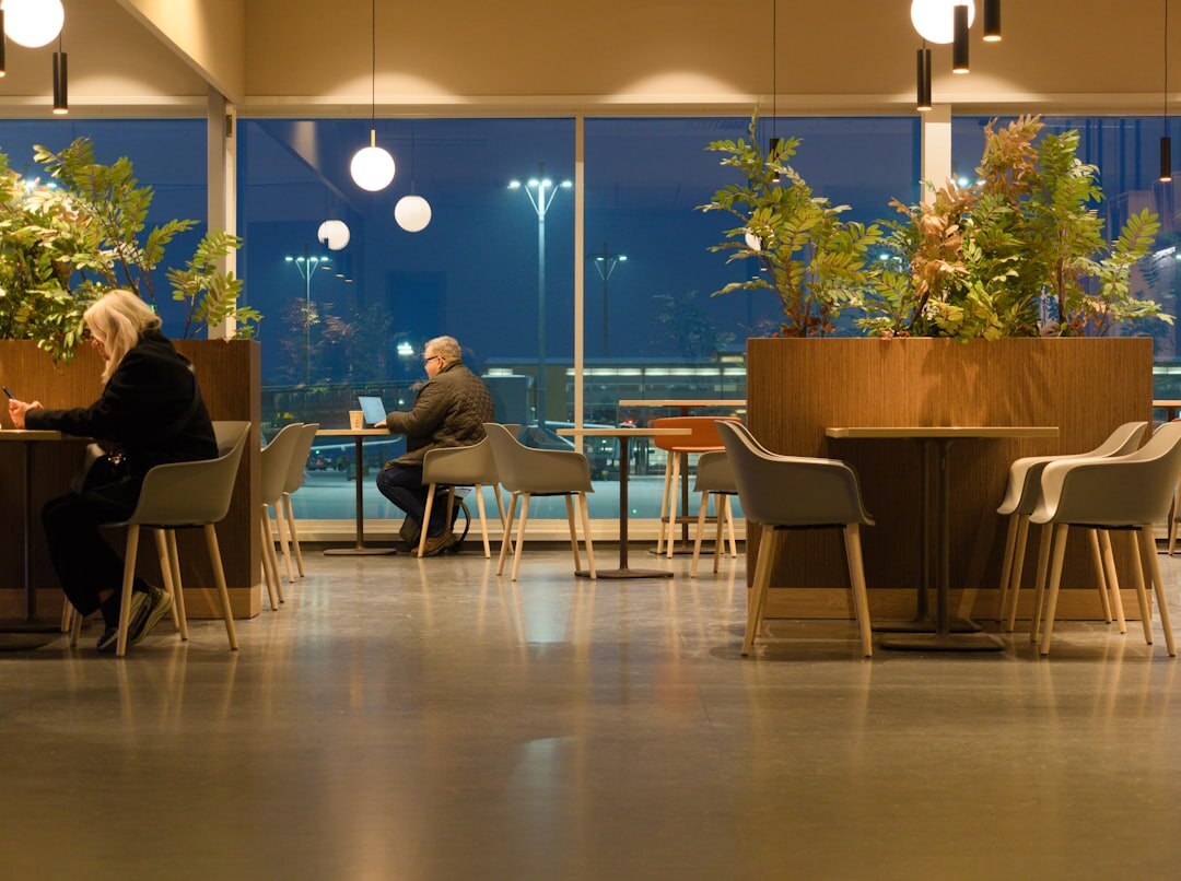 Professionals networking and chatting on lounge chairs in an office lobby